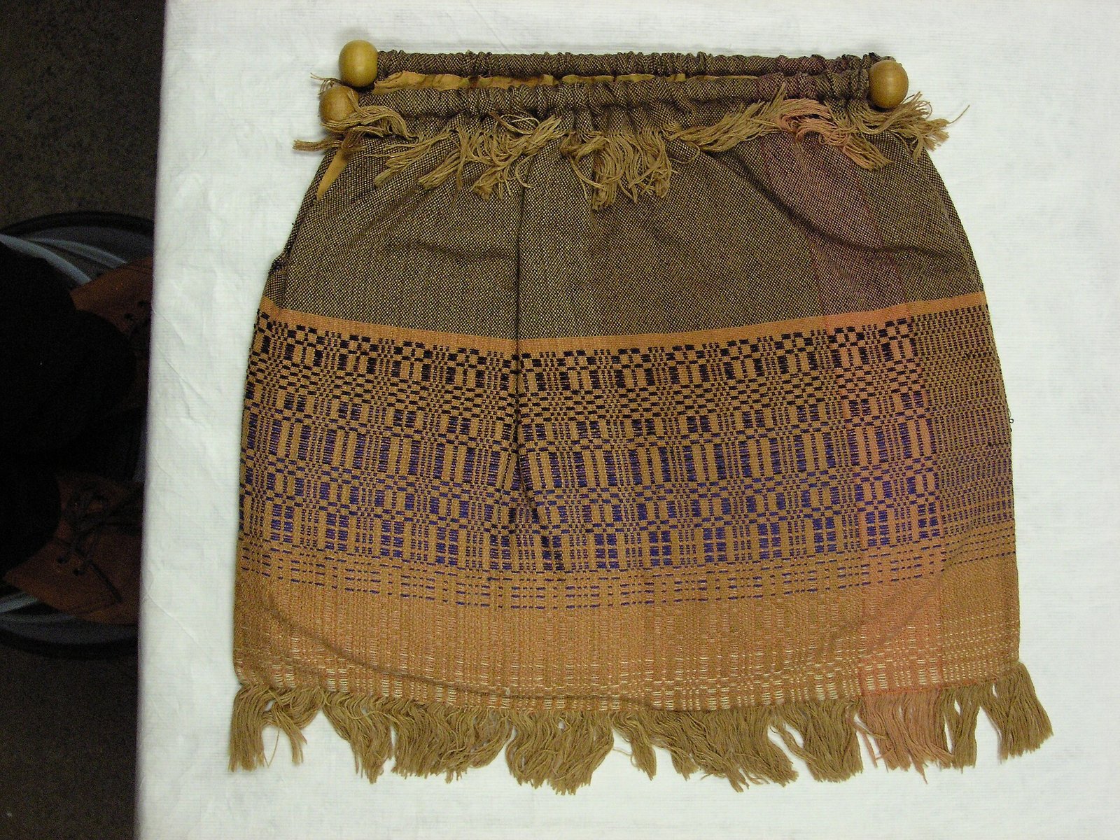 Peach and navy woven bag with a wooden frame